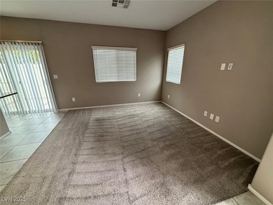 Spare room featuring light tile patterned floors and light carpet