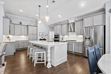 Kitchen featuring a center island with sink, dark 