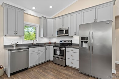 Kitchen featuring dark countertops, a sink, stainl