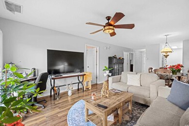 Living room with wood-type flooring and ceiling fa