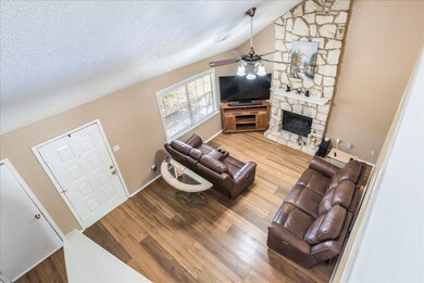Living area featuring vaulted ceiling, a fireplac