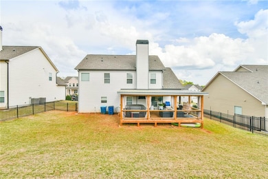Rear view of property with a shingled roof, a lawn