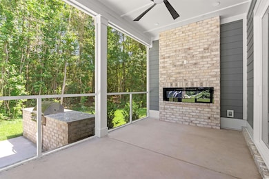 Unfurnished sunroom with area for grilling, ceiling fan, and an outdoor brick fireplace