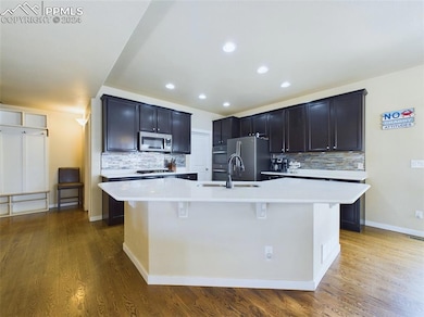 Kitchen with hardwood flooring with large island