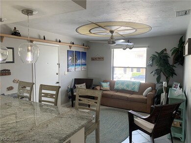 Living room with ceiling fan and light tile patterned flooring