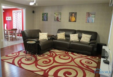 Living room with bamboo flooring and open to the k