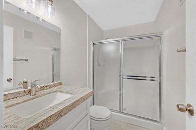 Full bath with toilet, vanity, visible vents, tile