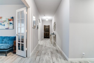 Corridor with wood finished floors and baseboards