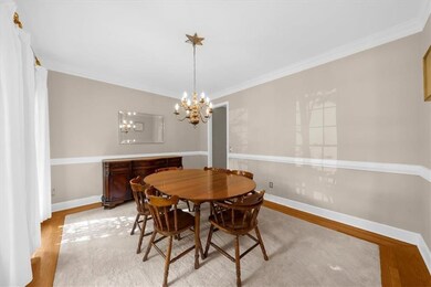 Dining area featuring ornamental molding, wood finished floors, and a chandelier