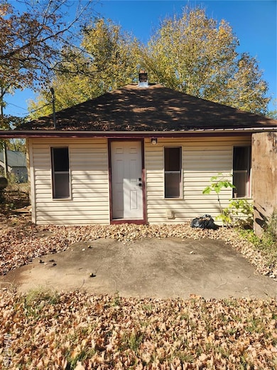 View of front of home featuring a chimney and roof with shingles