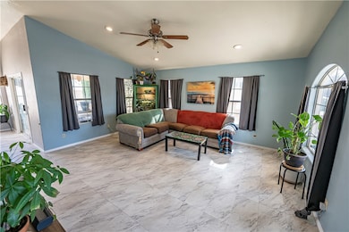 Living room featuring lofted ceiling, ceiling fan,