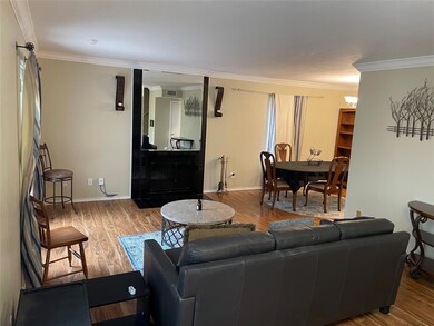 Living room with crown molding, baseboards, and wo