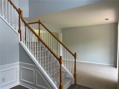 Stairway with wainscoting, carpet floors, and base