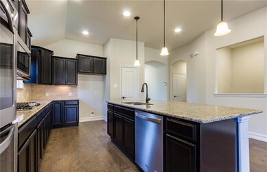 Kitchen with pendant lighting over the island, gra