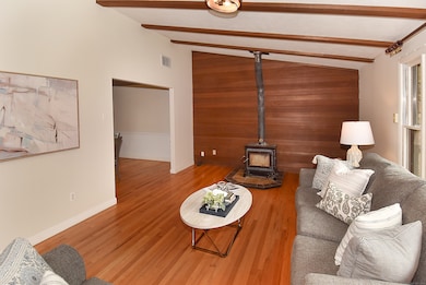 Open welcoming living room with wood burning stove for cozy winter evenings.