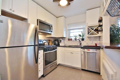 Kitchen has granite counters, subway tile backsplash and counter seating