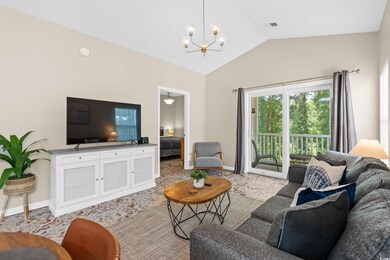 Living room with lofted ceiling and a notable chan