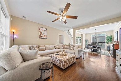 Living room featuring dark wood-style floors, a ch