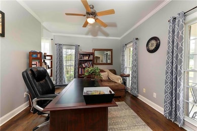Office area featuring a ceiling fan, wood finished floors, and crown molding