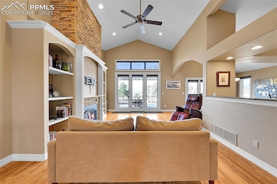 Living area with baseboards, visible vents, high v