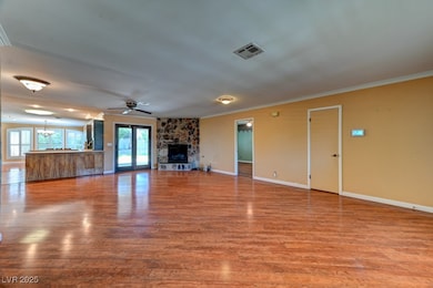 Unfurnished living room with crown molding, wood f