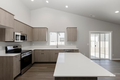 Kitchen with appliances with stainless steel finishes, dark wood finished floors, light brown cabinets, recessed lighting, and modern cabinets