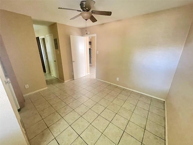 Empty room featuring ceiling fan, light tile patt