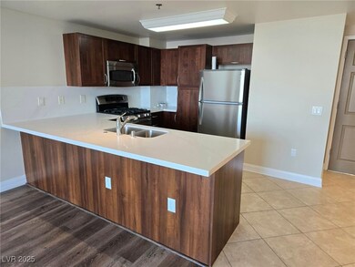 Kitchen with a peninsula, light countertops, a sin