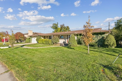 Single story home with an attached garage, a front lawn, and concrete driveway