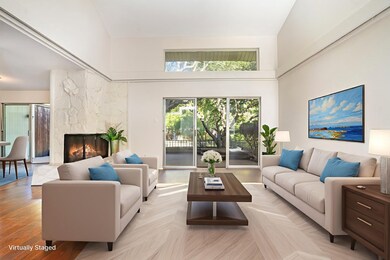 Living area featuring a high ceiling and a wood burning fireplace