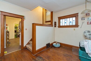 View of stairs from living room, note lots of natural woodwork and windows