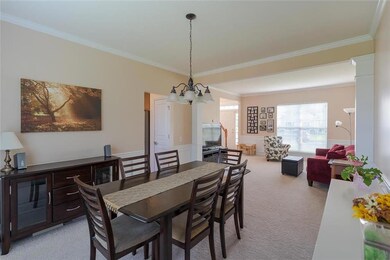 Formal dining and living room, complete with crown molding and wainscoting.
