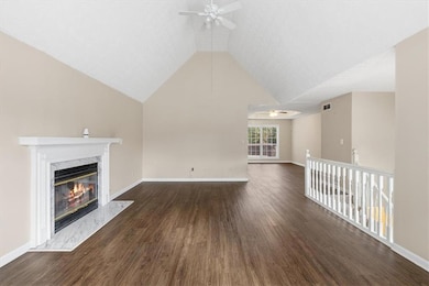 Unfurnished living room with dark wood-style floors, ceiling fan, a high end fireplace, and high vaulted ceiling