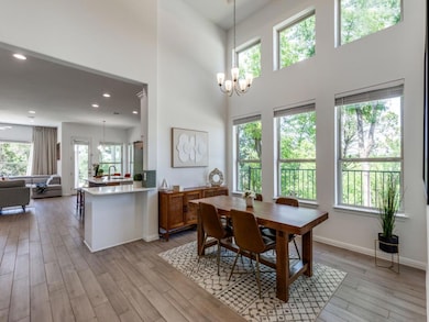 Dining area with a chandelier, a high ceiling, he