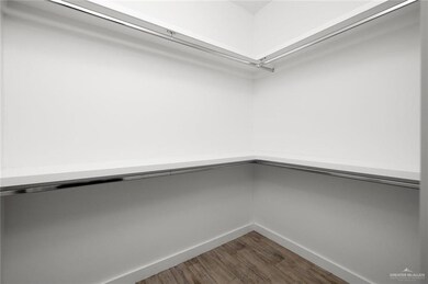 Spacious closet featuring dark wood-style floors