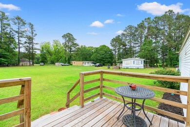 Wooden deck with a lawn and view of scattered tree