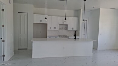 Kitchen with white cabinets, baseboards, a sink, a