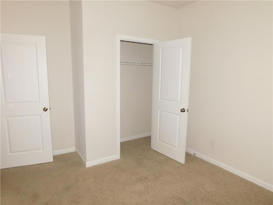 Unfurnished bedroom featuring light carpet and a closet