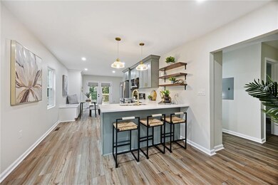 Kitchen with a kitchen bar, light countertops, gray cabinetry, light wood-style flooring, and recessed lighting