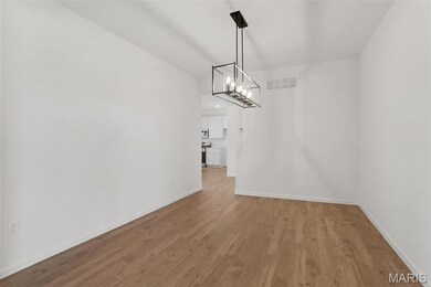 Unfurnished dining area featuring wood finished floors and a chandelier
