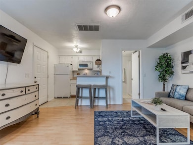 Living room featuring light wood-style floors and a textured ceiling