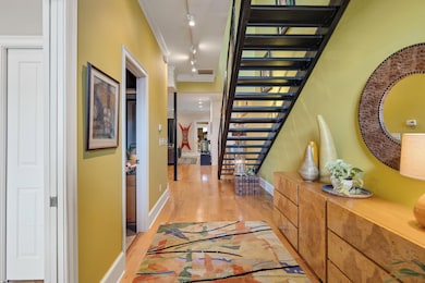 Hall with track lighting, stairs, light wood-style flooring, and crown molding