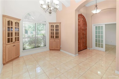 Foyer featuring arched walkways, a chandelier, and light tile patterned floors