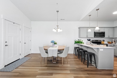 Dining area featuring light wood-type flooring and a chandelier