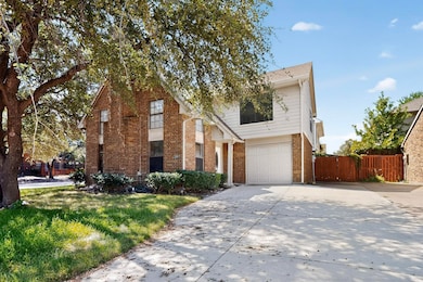 Traditional home featuring driveway, brick siding, and an attached garage
