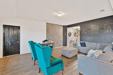 Living room with baseboards, visible vents, an acc
