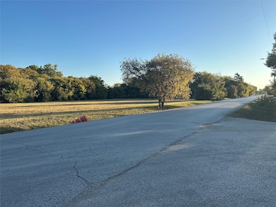 View of asphalt street with a wooded view