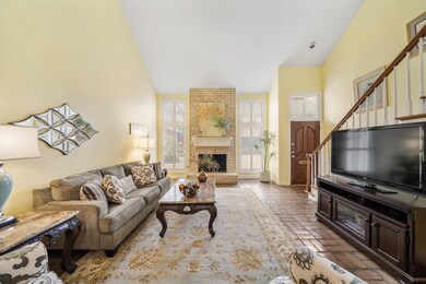 Offering numerous furniture placement opportunities, a two-story beamed ceiling & charming tile flooring sets the stage in this beautiful living space.