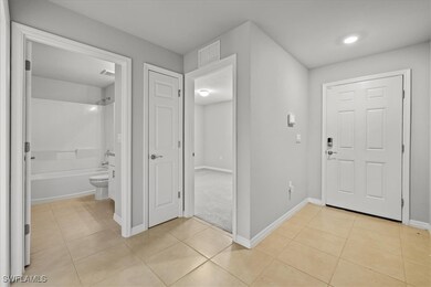 Entryway featuring light tile patterned floors, visible vents, and baseboards