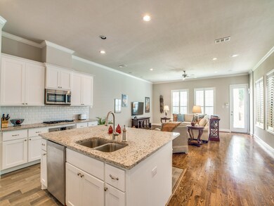 Enter the kitchen from the dining room. White cabi